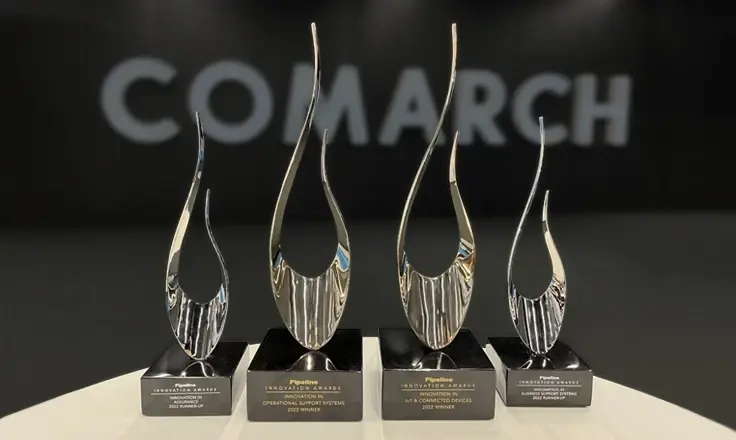 Four silver Pipeline Innovation Awards on black bases displayed in front of a white Comarch logo.
