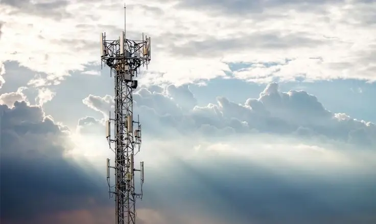 450 MHz tower against a cloudy sky, with sunbeams breaking through heavy clouds.