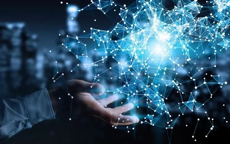 A hand positioned under a glowing blue digital network of connected dots and lines against a blurred city background.