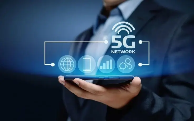 A person holding a smartphone with a 5G network graphic and icons for world, phone, signal, and settings floating above.