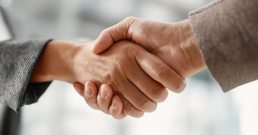 Close-up of a handshake between two people in business attire.