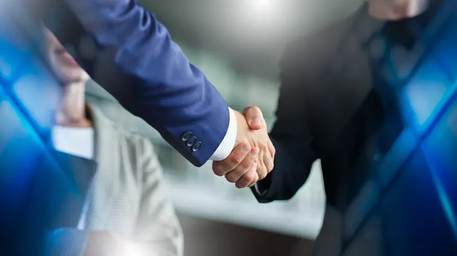 Close-up of businessmen shaking hands with a woman blurred in the background, set within a blue abstract network.